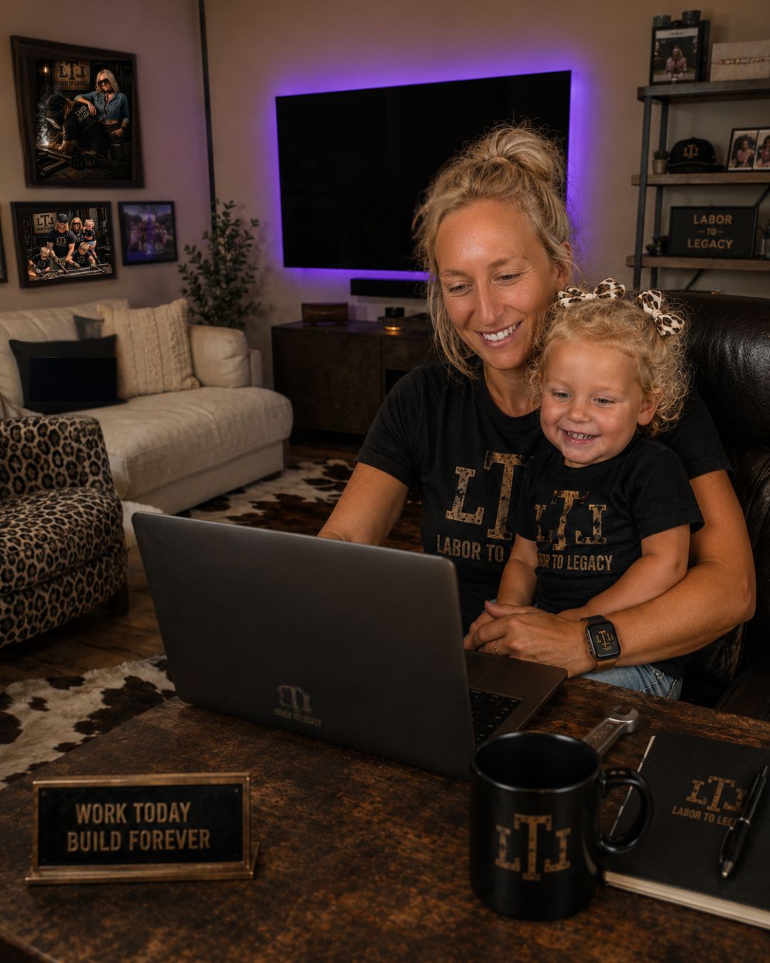 Mother and young daughter smiling at a laptop in a Labor To Legacy living room